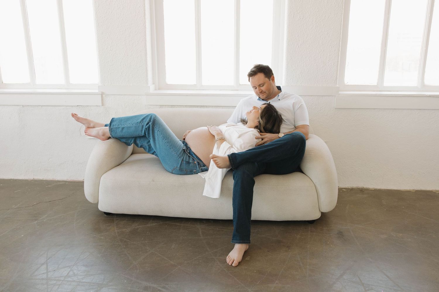Artistic pregnancy portrait sequence showing expecting mother relaxing on white furniture.
