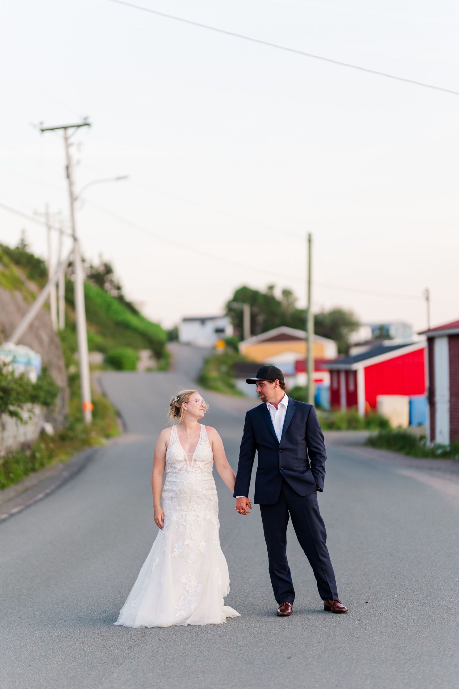 A couple on their wedding day poses for creative tilt-shift photos on a quiet road in three sequential shots.