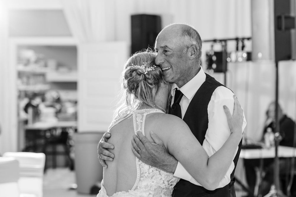 A tender moment captured in black and white as two people share an intimate dance at a wedding reception.