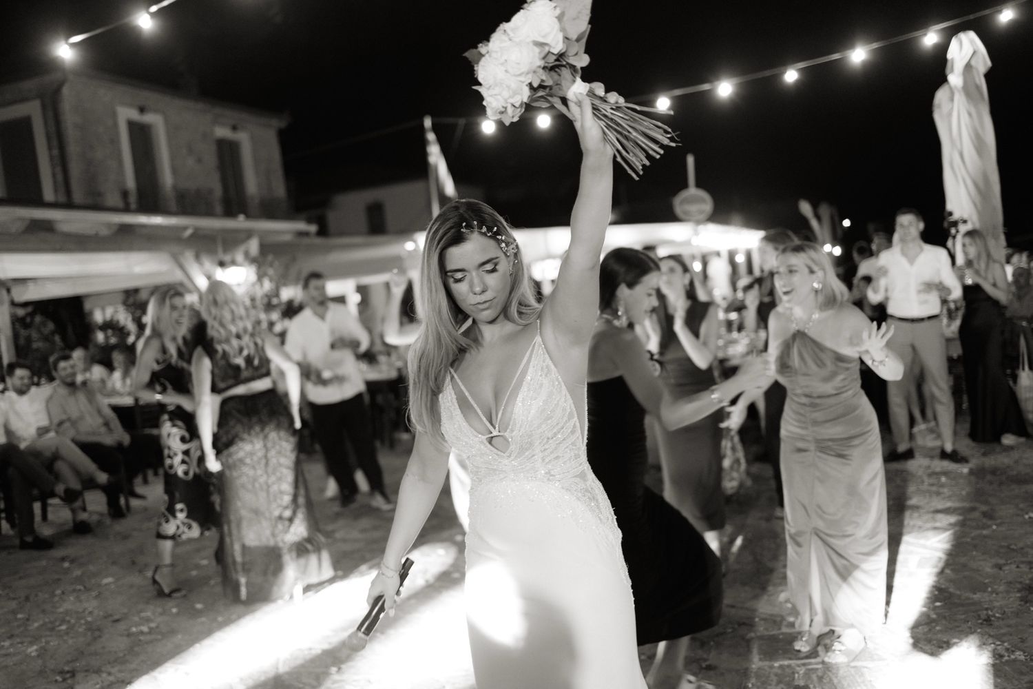 A collage of black and white candid party photos showing people dancing under string lights at a nighttime celebration.
