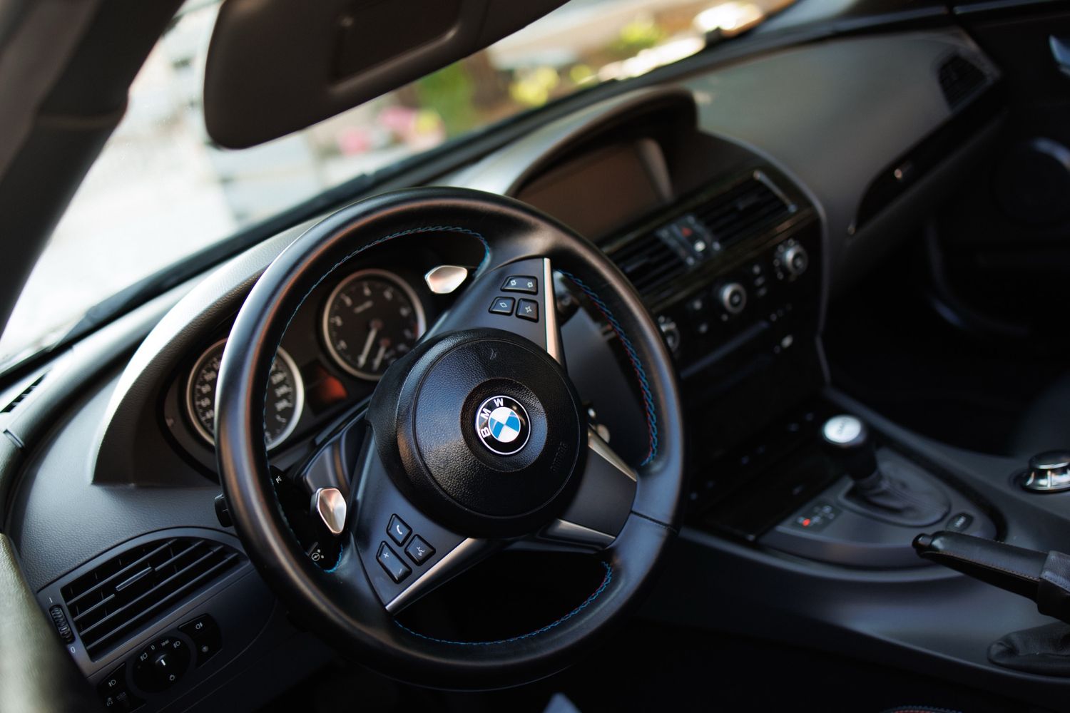 BMW car steering wheel interior details with carbon fiber accents and control buttons seen from different angles.