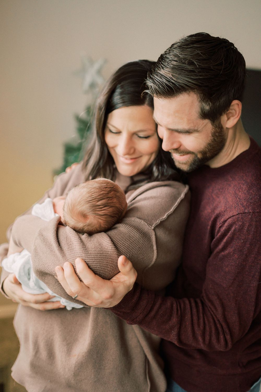 Intimate family moment with newborn baby during winter holiday season.