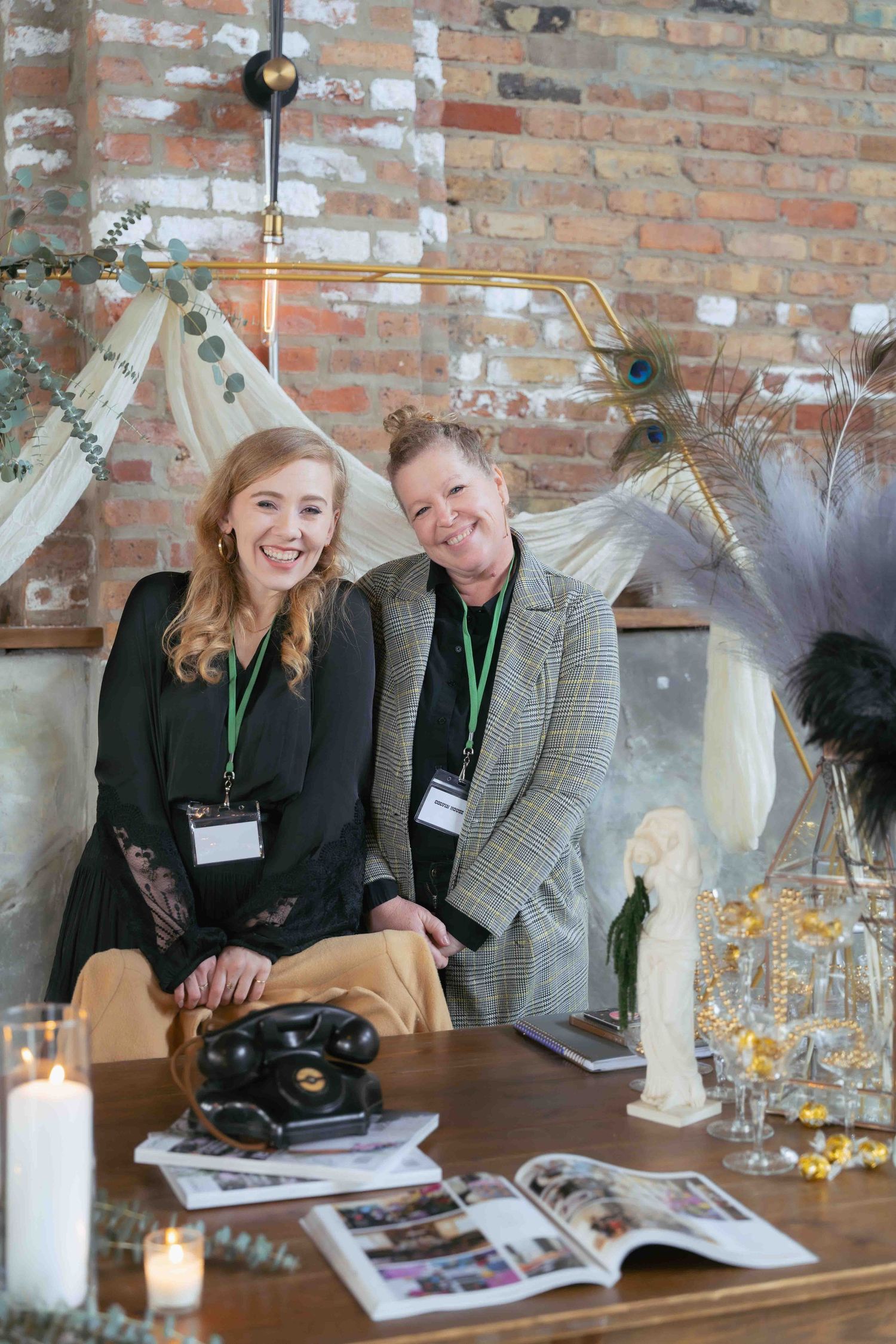 Two event coordinators at a decorated display table with vintage cameras and printed materials. At Fairlie, Chicago