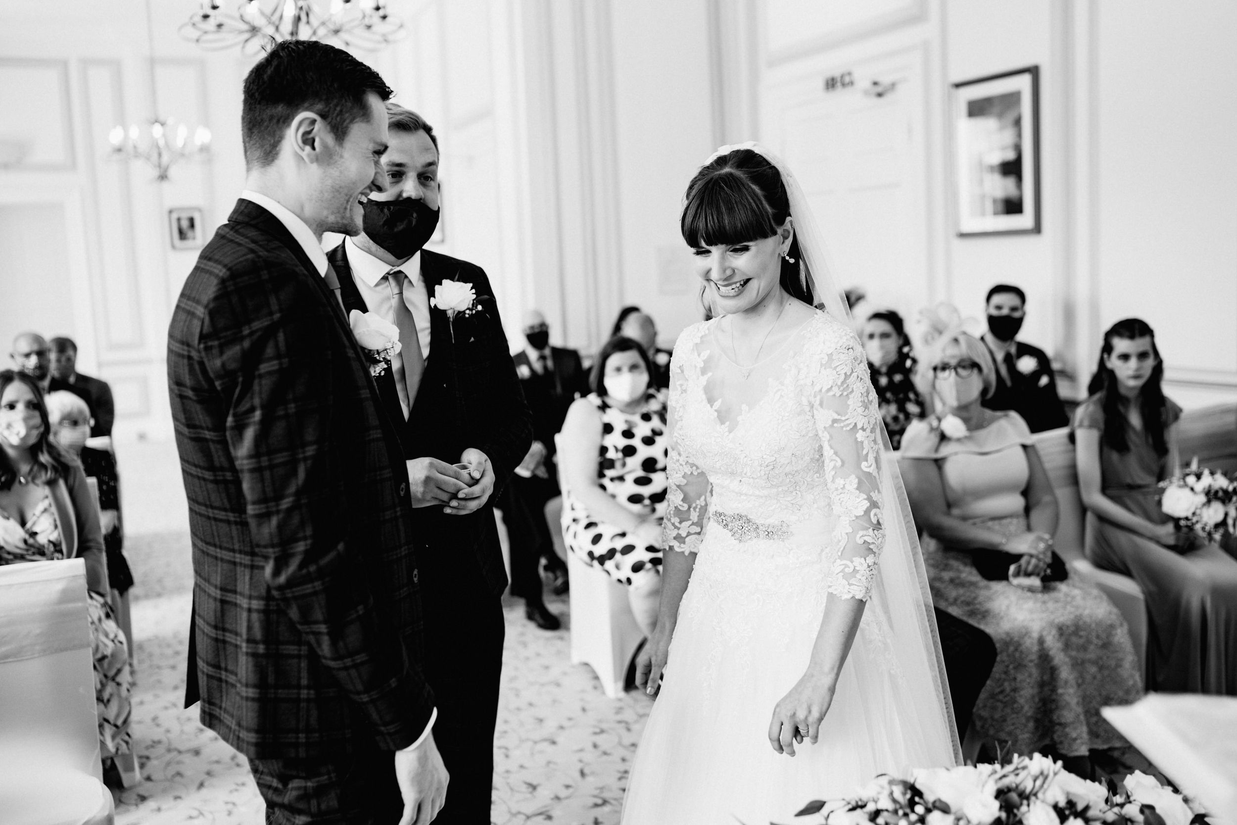 Black and white wedding ceremony photo showing participants during formal proceedings.