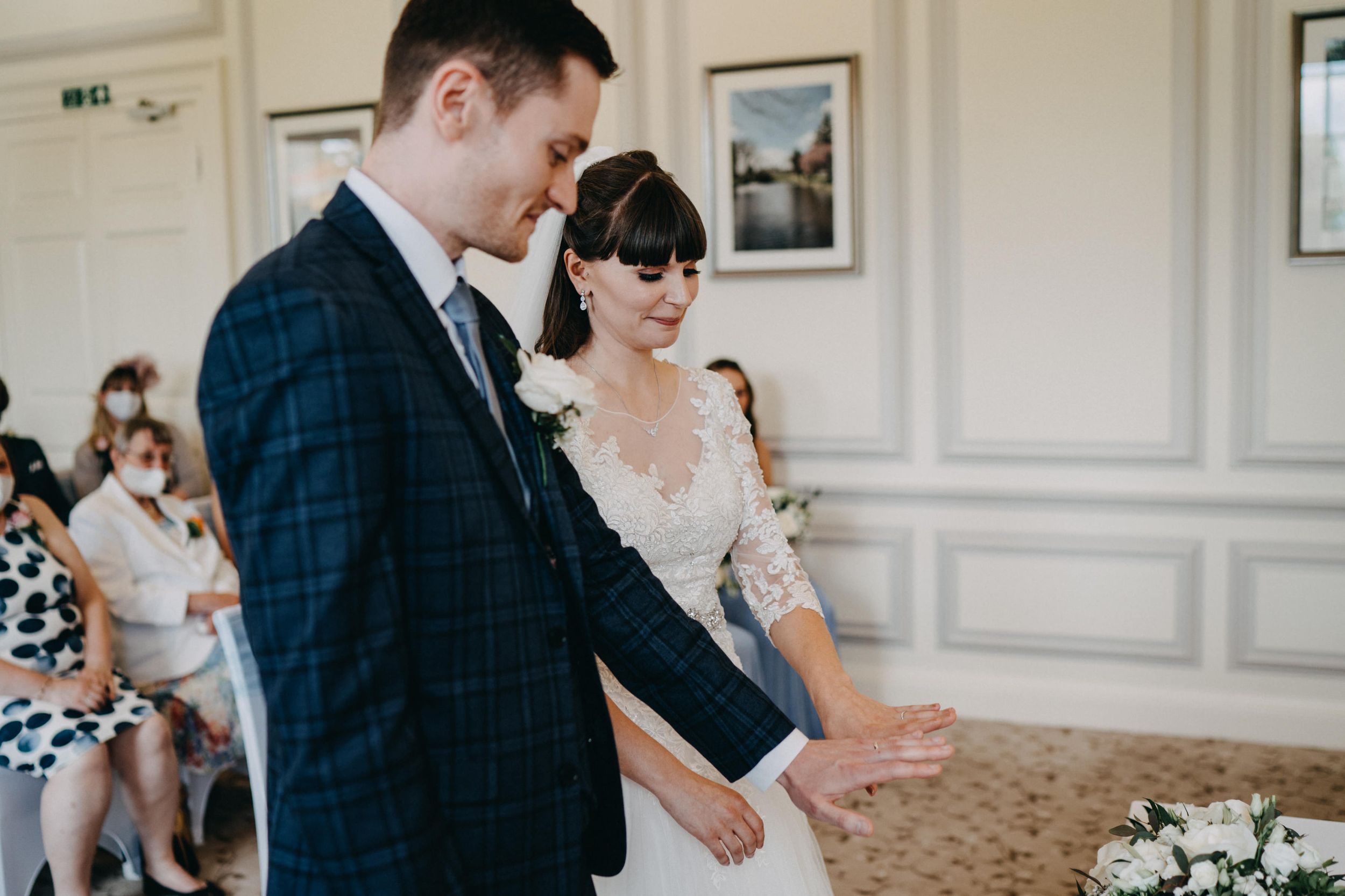 Wedding ceremony in elegant room at Harrowden Hall with classic decor and ornate details.