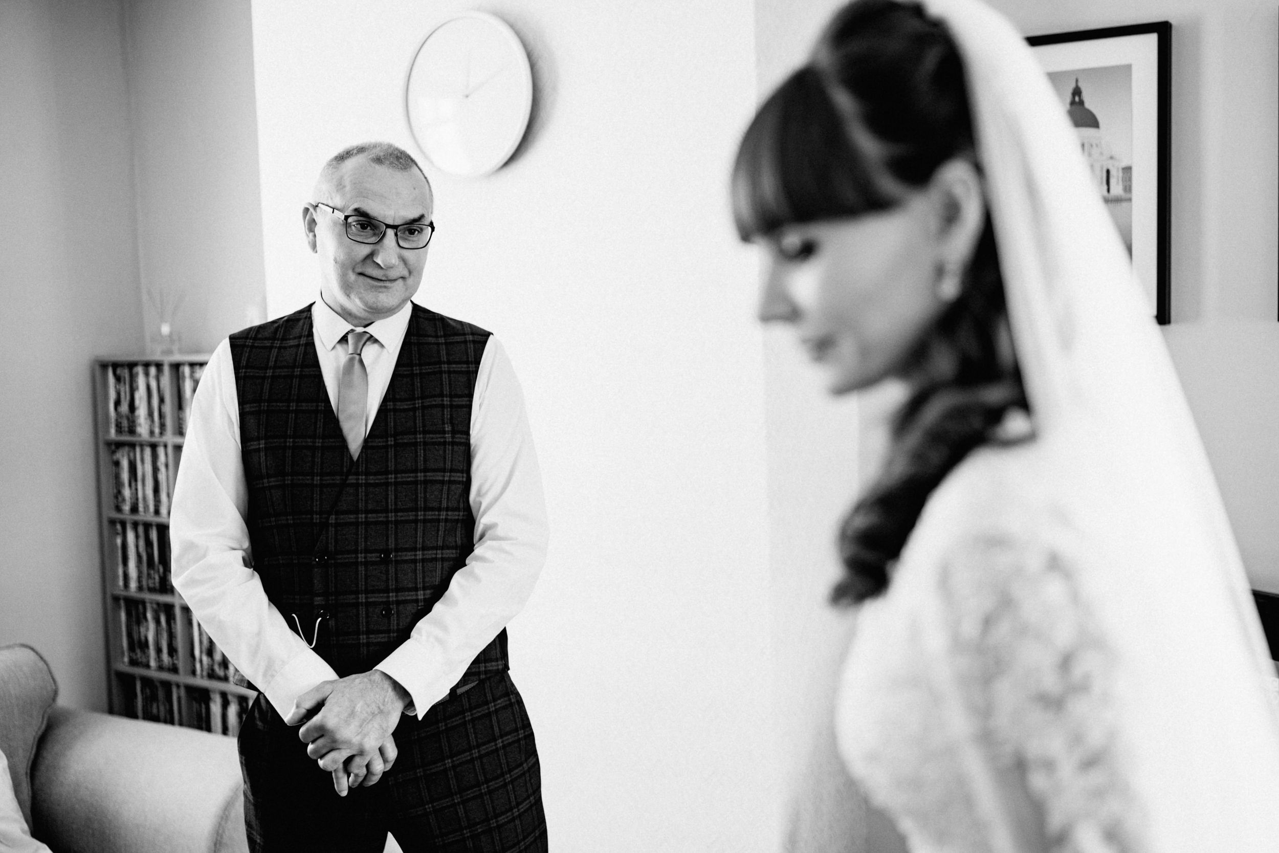 Black and white photo capturing emotional moments during wedding preparation.