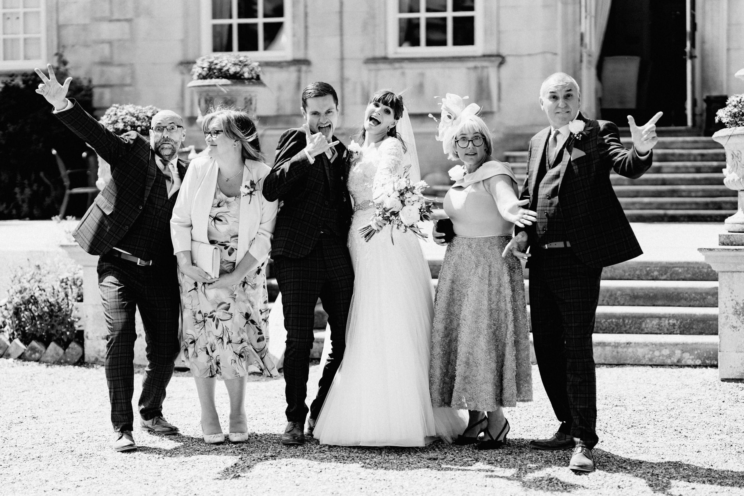 Black and white portrait of wedding group on historic building steps.
