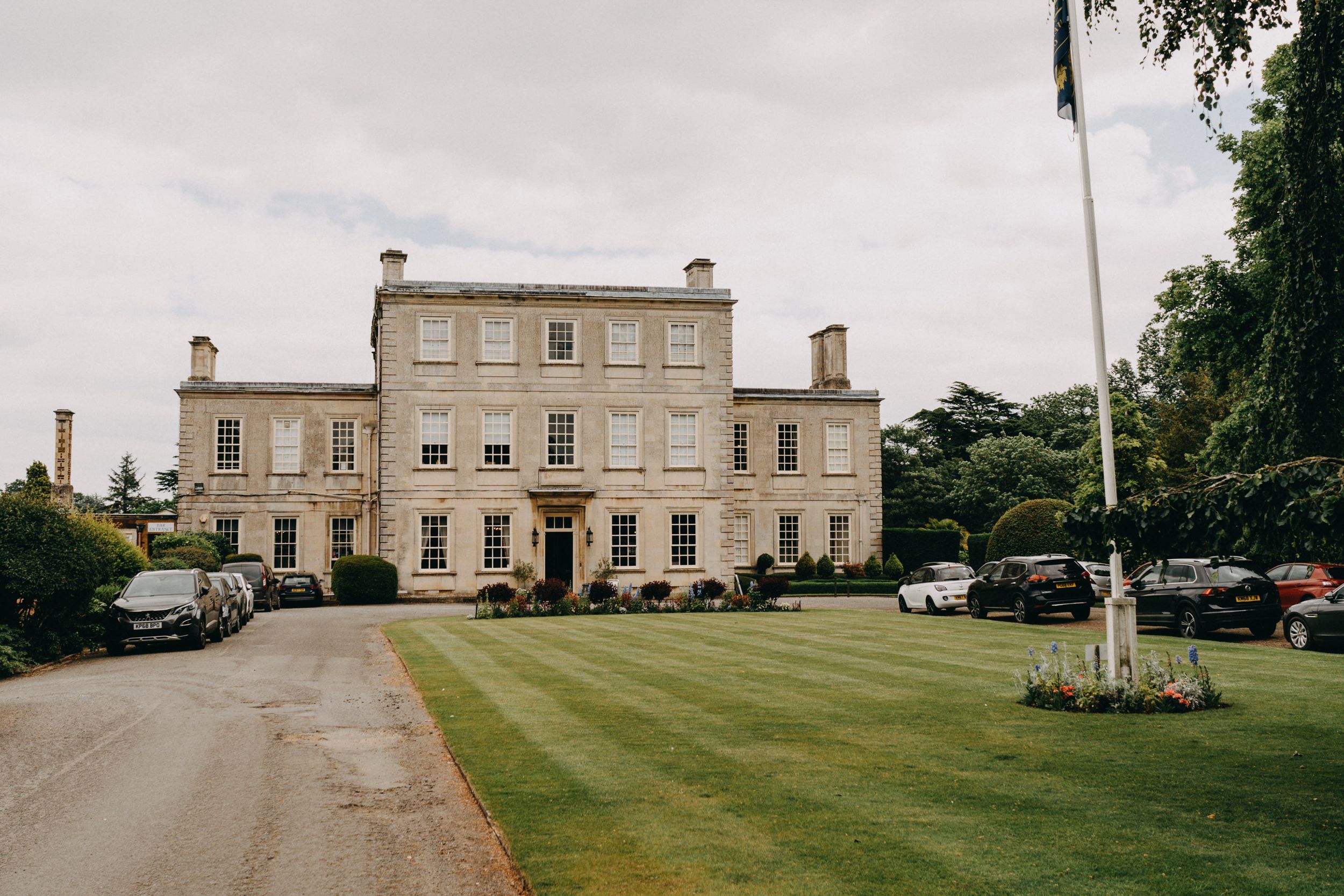 Harrowden Hall - grand historic mansion venue with manicured grounds and parked cars.