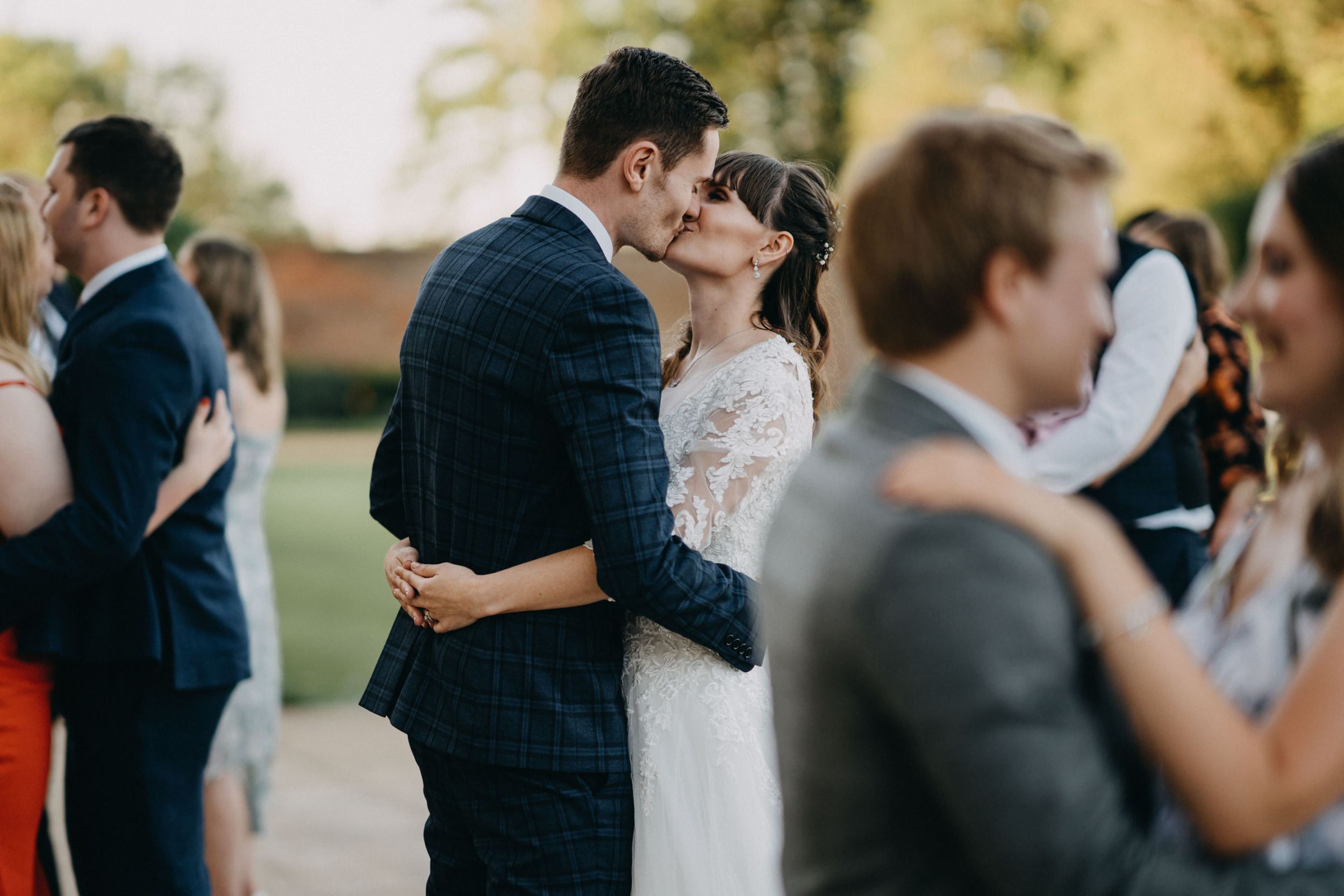 Romantic moment between newlyweds during outdoor wedding reception.