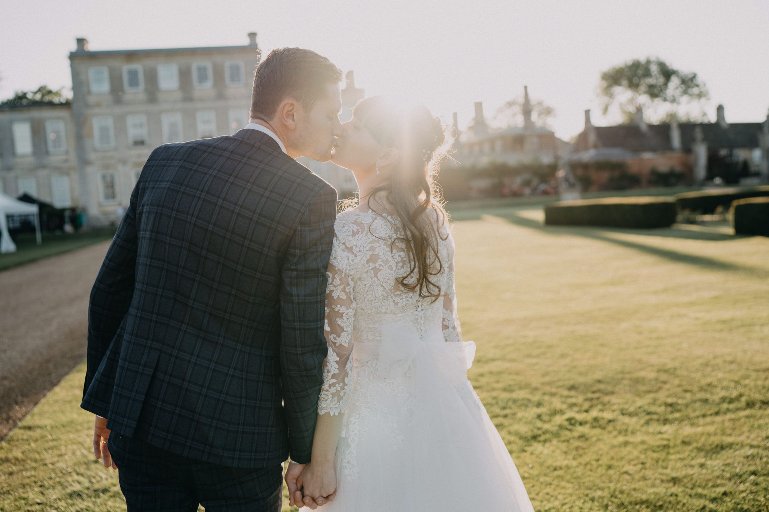 Newlyweds share an intimate moment in warm sunset light on their wedding day.