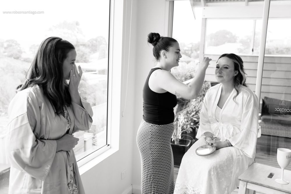 Wedding day preparations taking place by a bright window with styling in progress.
