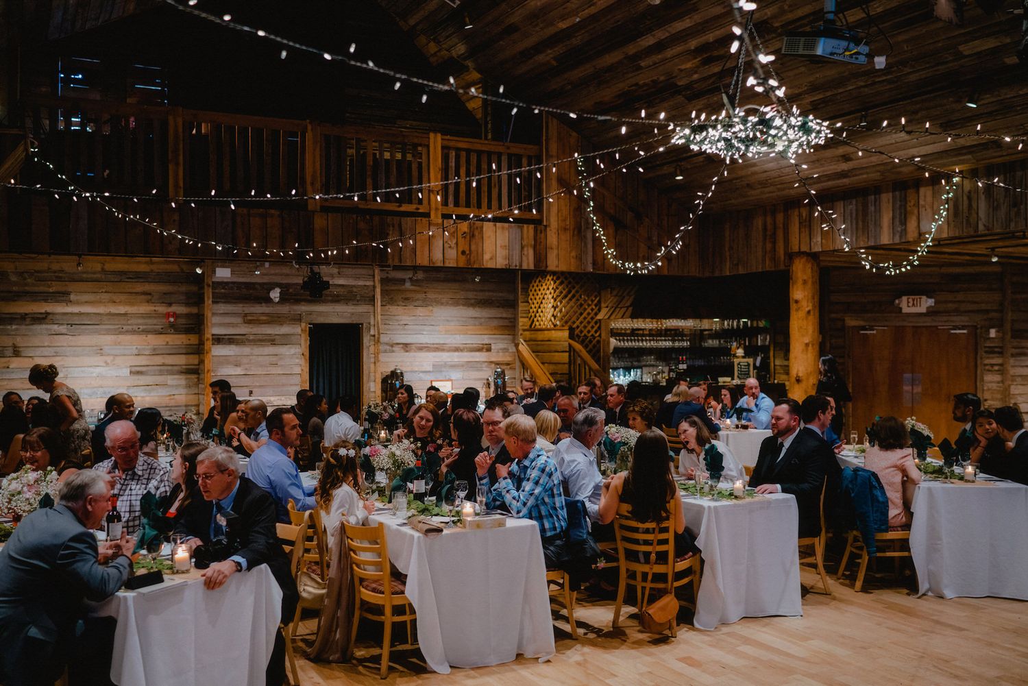 Indoor reception venue with string lights and elegant table settings.
