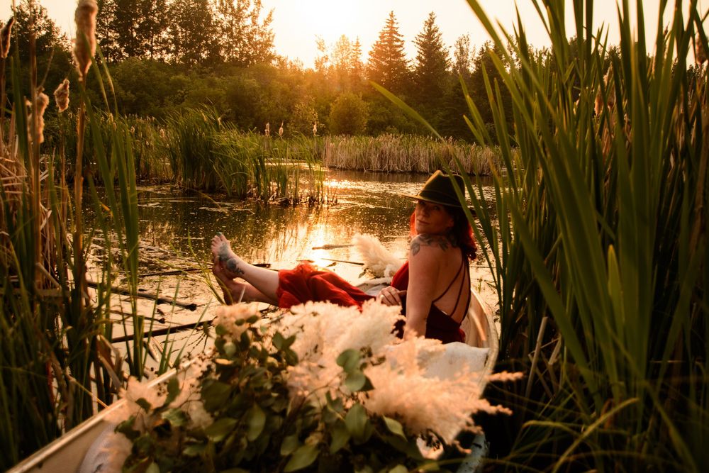Ethereal sunset scene at a pond with tall reeds and water lilies creating a dreamy natural atmosphere.