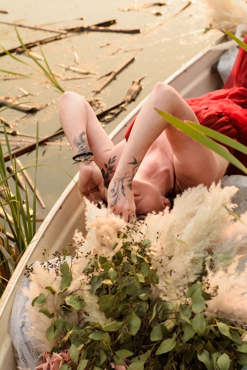 White floral arrangement nestled among cattails and pond vegetation in warm natural lighting.