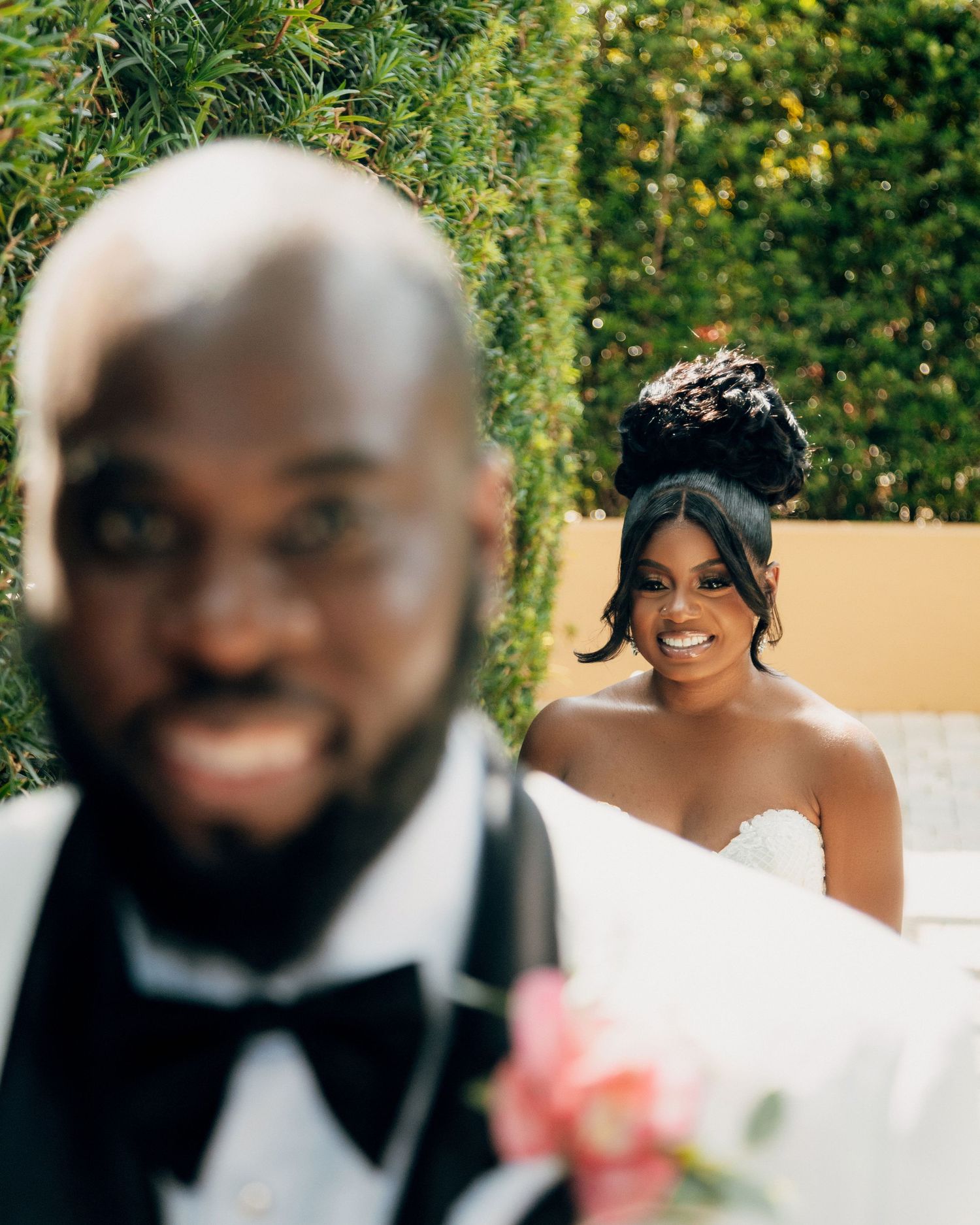 Wedding couple captured in a candid moment outdoors with soft bokeh effect.