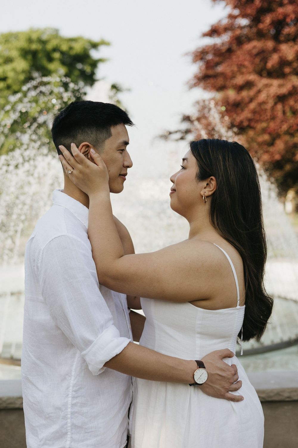 A couple wearing white embraces and laughs together during an outdoor photo session. Kitchener Ontario Wedding Photography