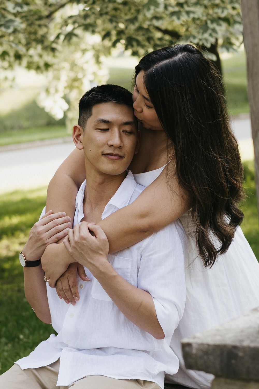 A tender romantic moment between a couple embracing outdoors in a park on a sunny day at Rockway Gardens in Kitchener Ontario