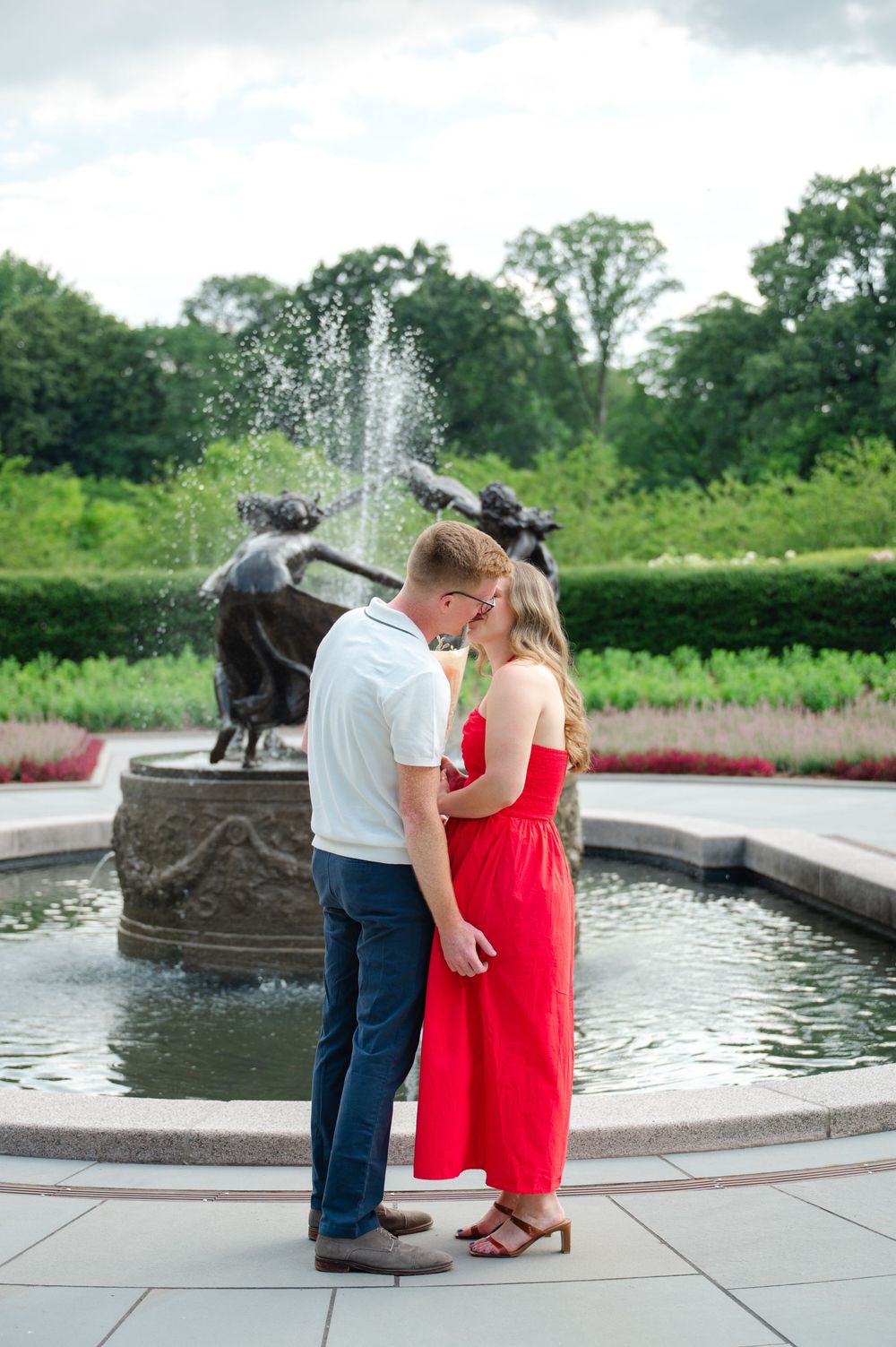 A couple kisses after their surprise proposal in the Conservatory Garden of Central Park, NYC. Photo by Joliette Marie Photography.