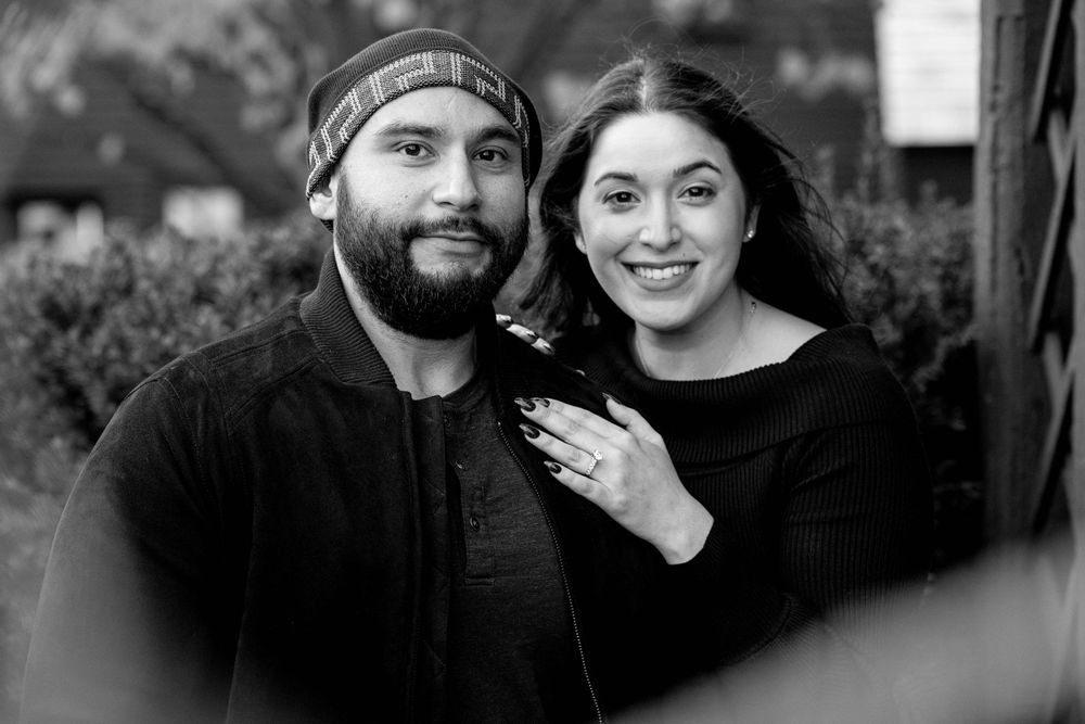 A happy couple poses together in black and white for an intimate engagement portrait.