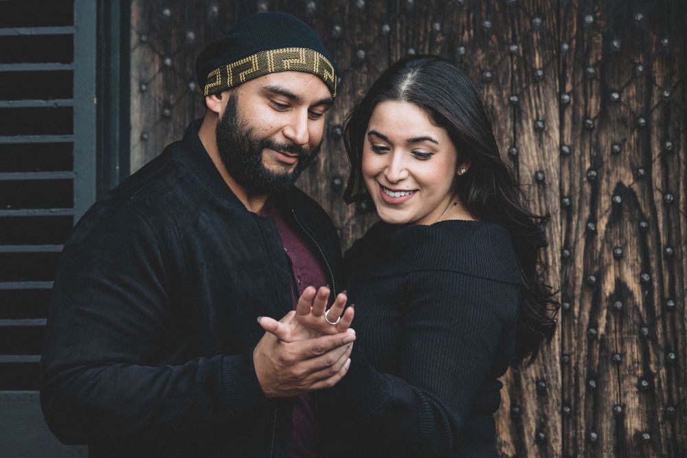 A couple shares an intimate moment while looking at something in their hands.