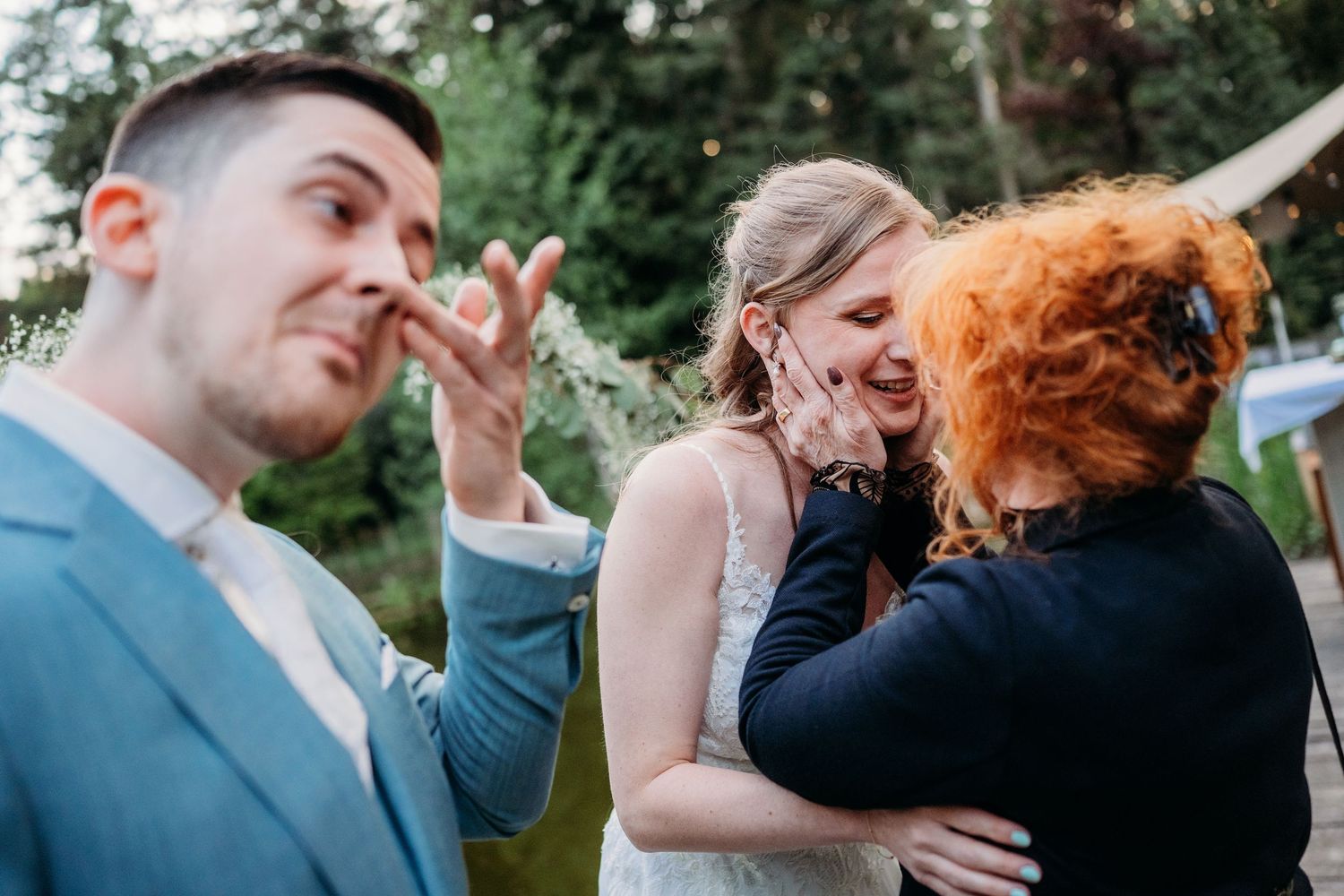 An emotional moment shared between guests during an outdoor wedding celebration.