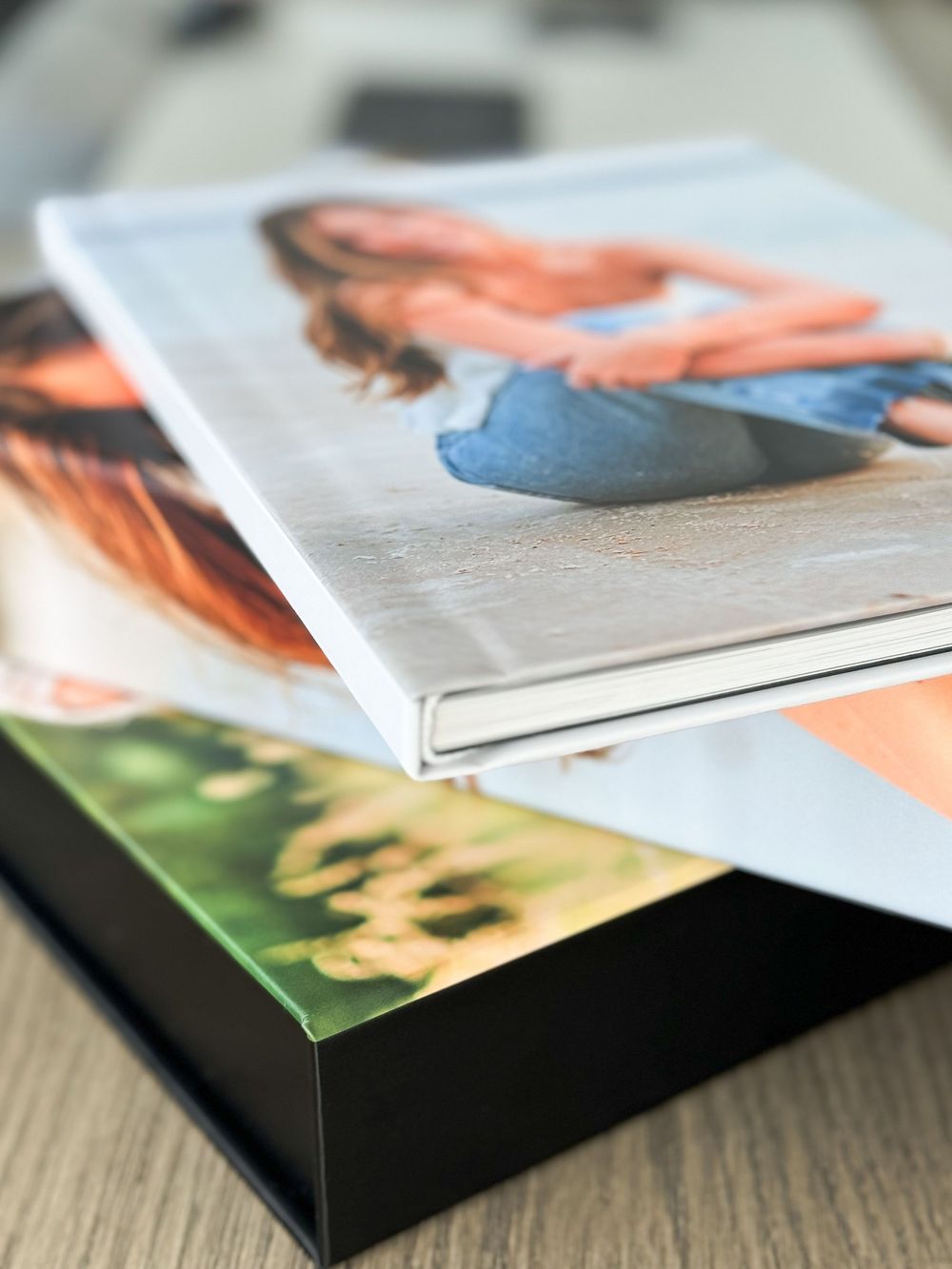 A close-up view of a photo album or book with layered pages showcasing colorful images on a wooden surface.