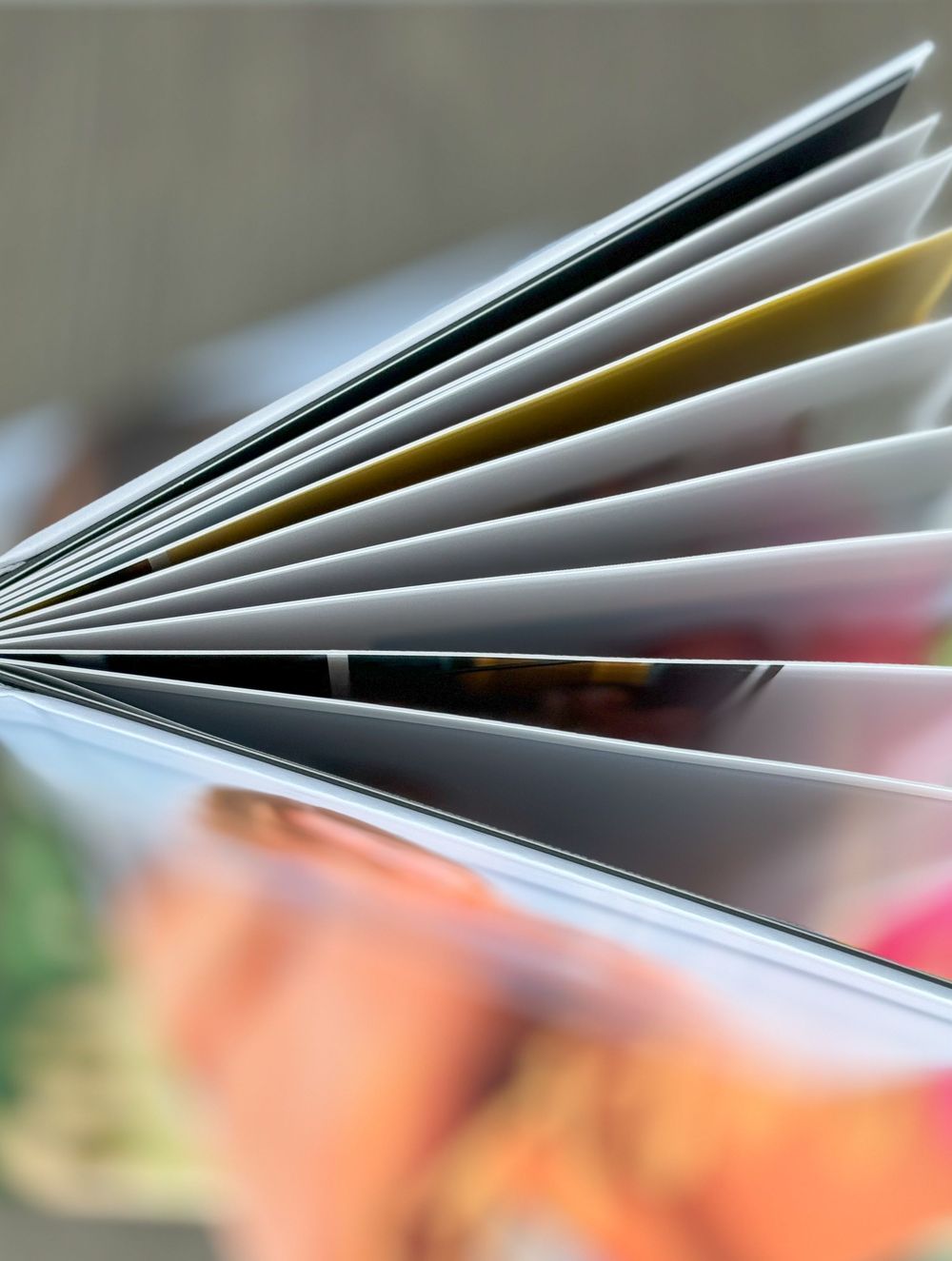 Close-up view of fanned out photo album pages showing blurred images in soft focus.