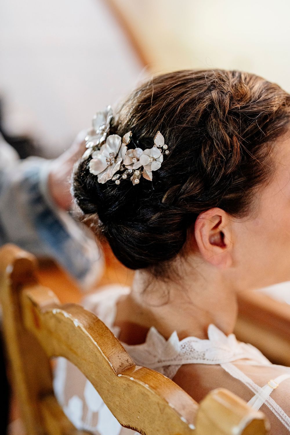 Close-up of an elegant bridal hairstyle with delicate white floral hair accessories in an updo style.