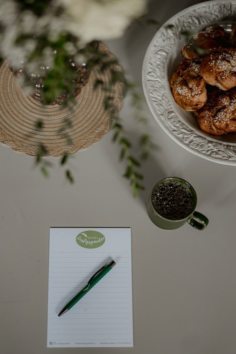 Overhead view of breakfast setup with pastries, notepad and green drink.