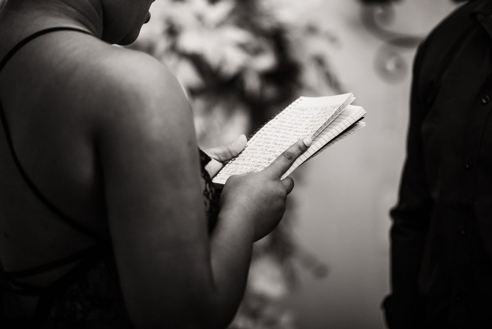 Someone reads a book while sitting in a black and white artistic portrait.