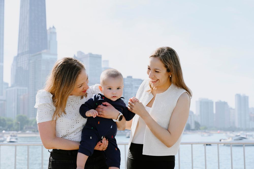 Family enjoying a sunny day by the river with Chicago skyline in background.
