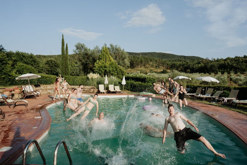 The whole wedding party jumping into the pool during the pre-wedding party