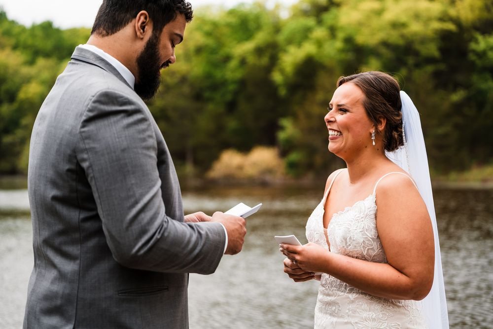 A couple exchanges vows and rings during an intimate outdoor wedding ceremony by the water.