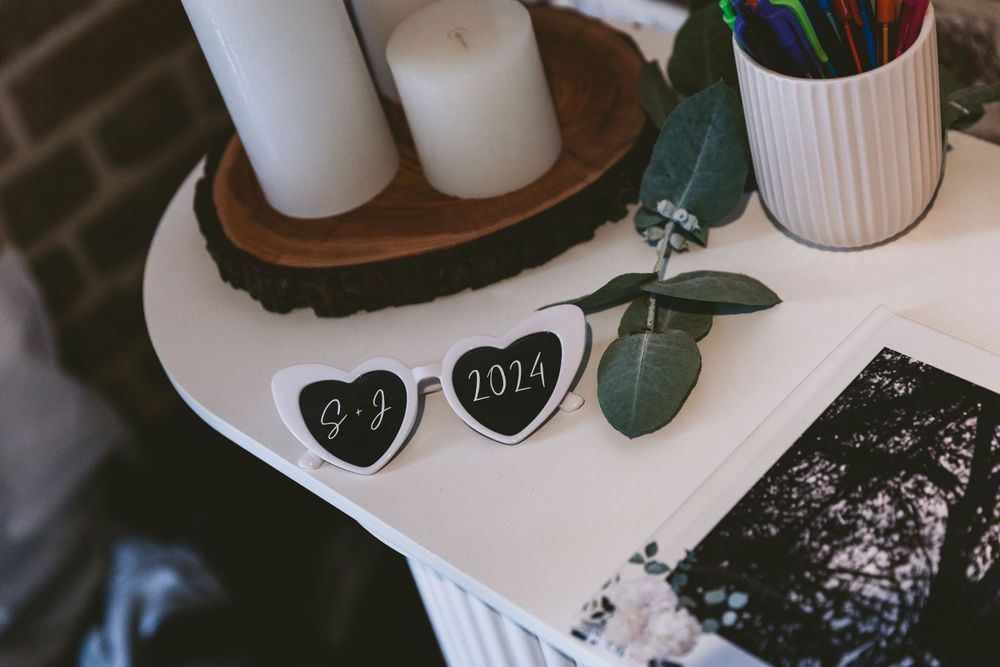 Wedding detail shot of decorative items including heart shapes and candles on white surface.
