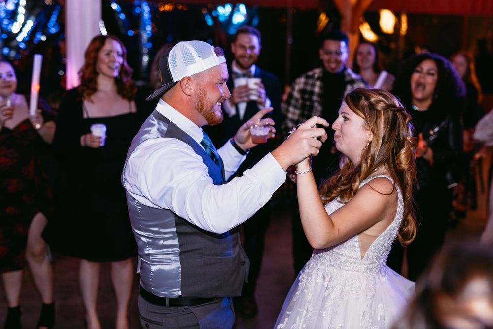 Wedding reception dance captured with warm lighting and celebratory atmosphere.