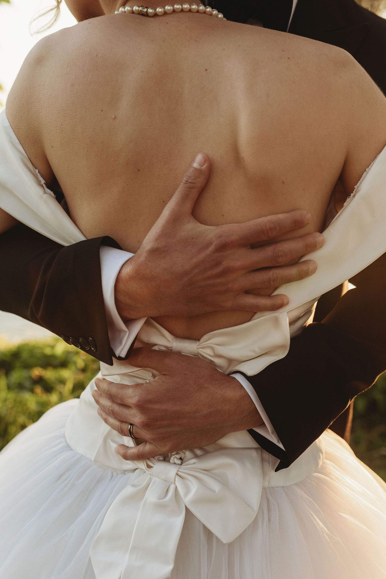 Sequence of romantic wedding photos showing a close-up embrace with hands around a white bridal gown.