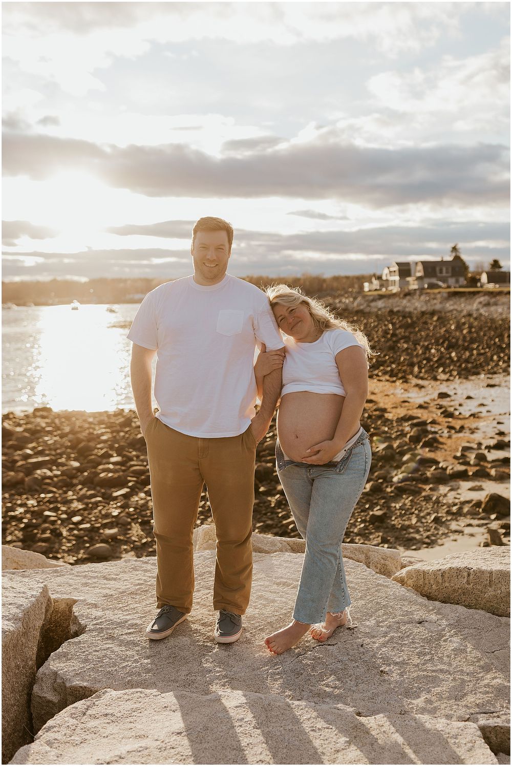 Couple taking maternity photos at the beach in New Hampshire