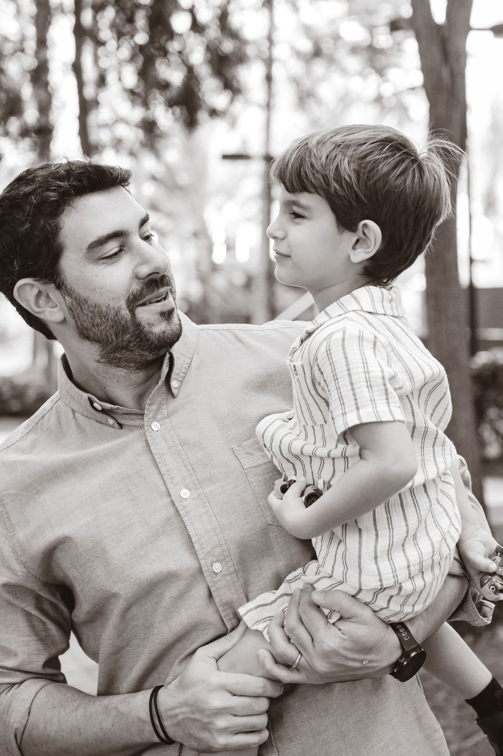 A black and white photo sequence showing tender playful moments between parent and child outdoors.