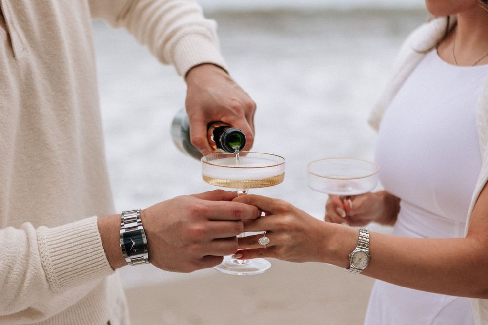 Couple popping champagne after saying yes during Santa Barbara proposal.