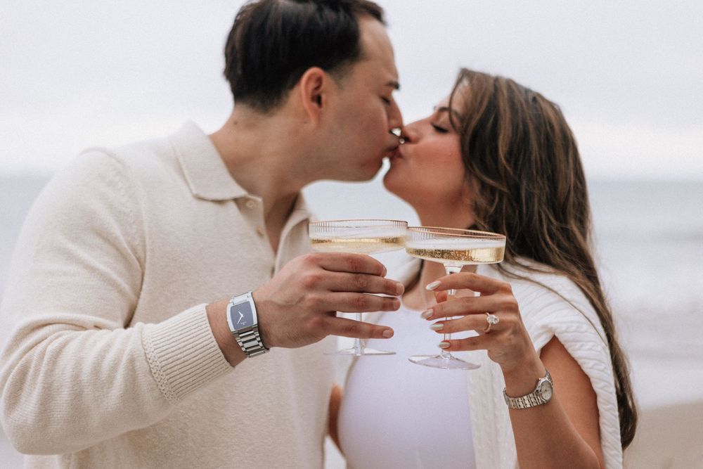 Couple toast champagne glasses after Santa Barbara proposal