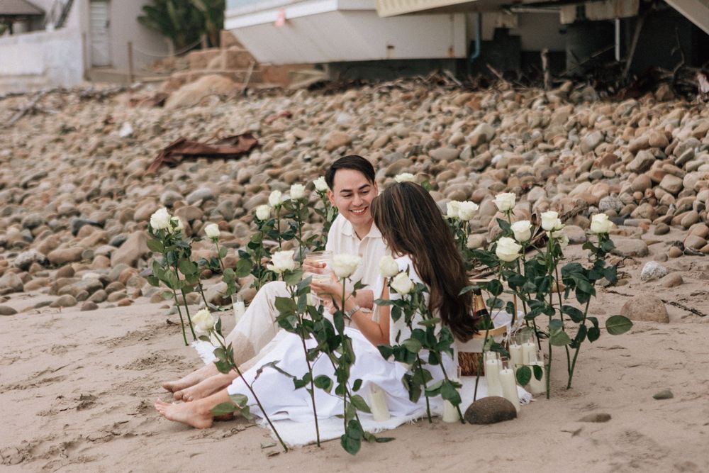 Couple celebrating engagement on a cloudy beach in Montecito.