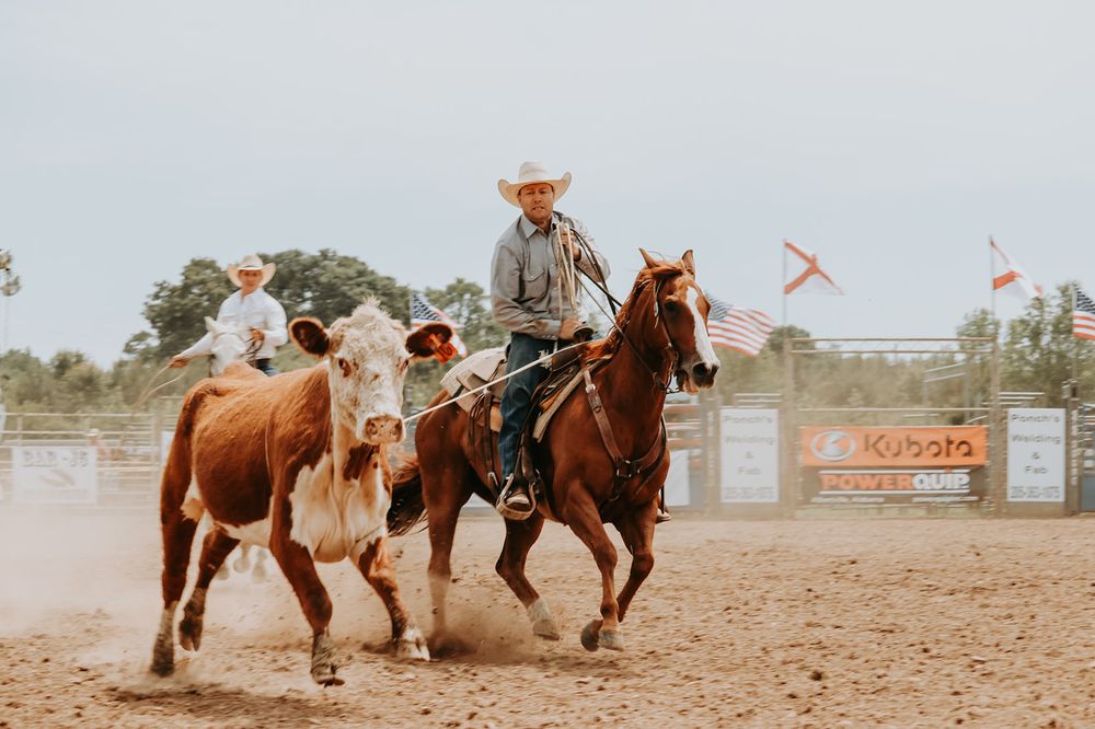 Cowboys compete in a high-stakes rodeo event as horses gallop through a dusty arena during an exciting competition.