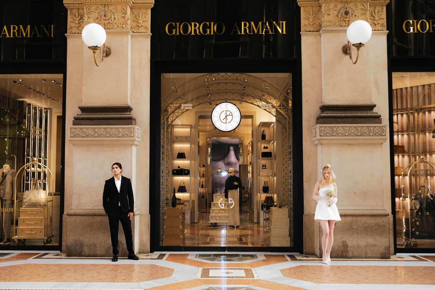A luxury Giorgio Armani storefront with two people standing on opposite sides of the elegant entrance.