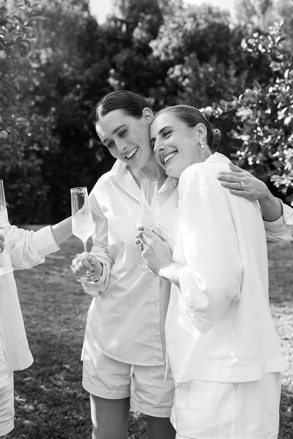 A sequence of candid black and white images showing two people in white shirts sharing joyful moments outdoors.
