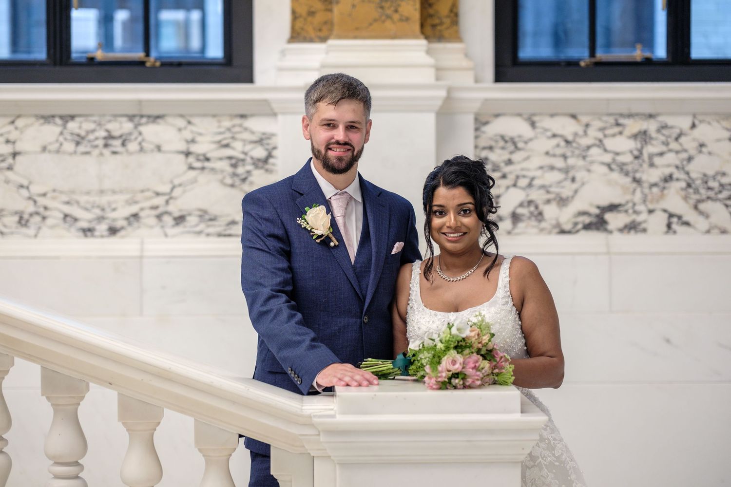 Joyful newlyweds share candid moments together during their outdoor wedding photography session at a rustic stone venue.