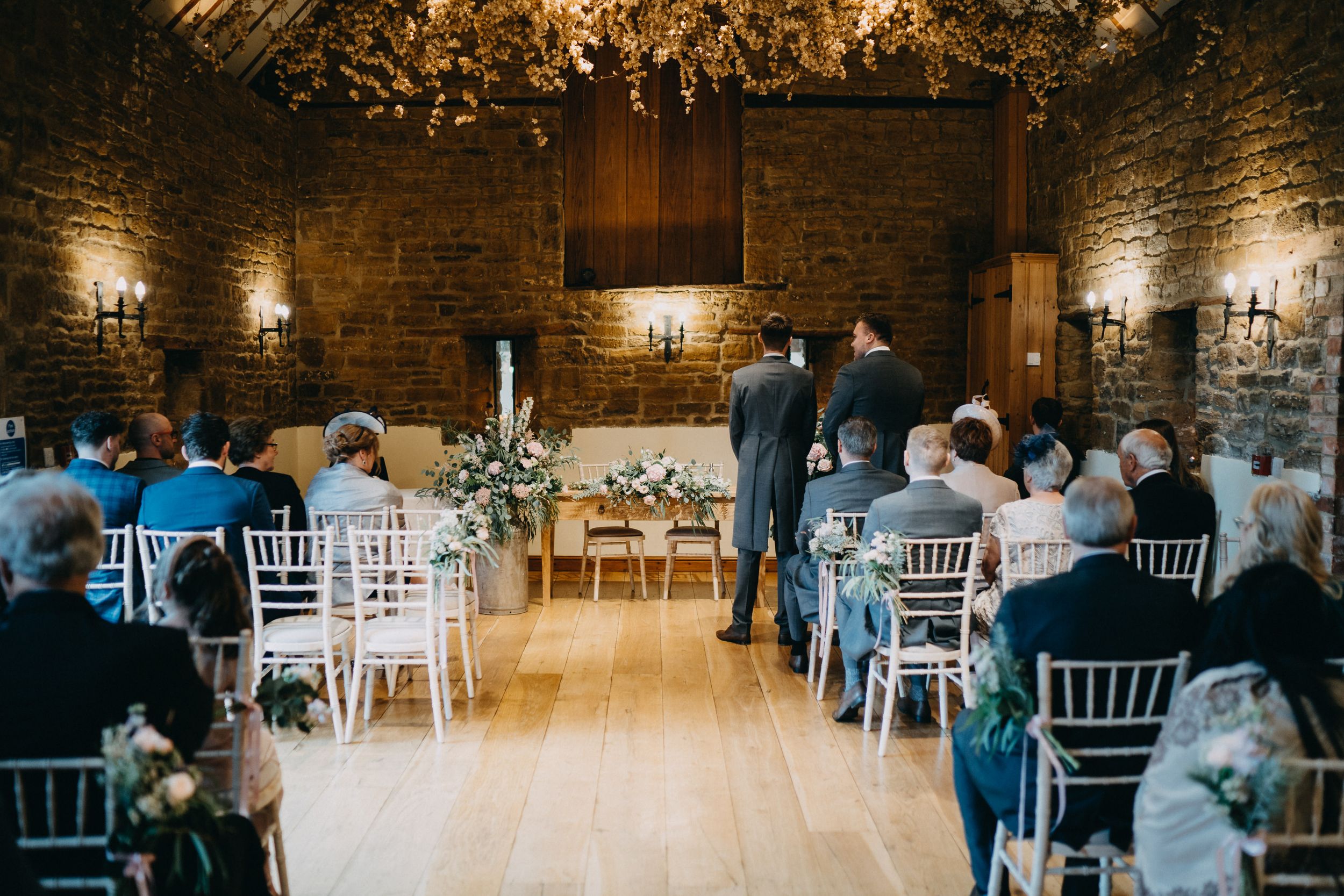 Wedding ceremony setup in rustic brick of Crockwell Farm with white chairs and romantic lighting.