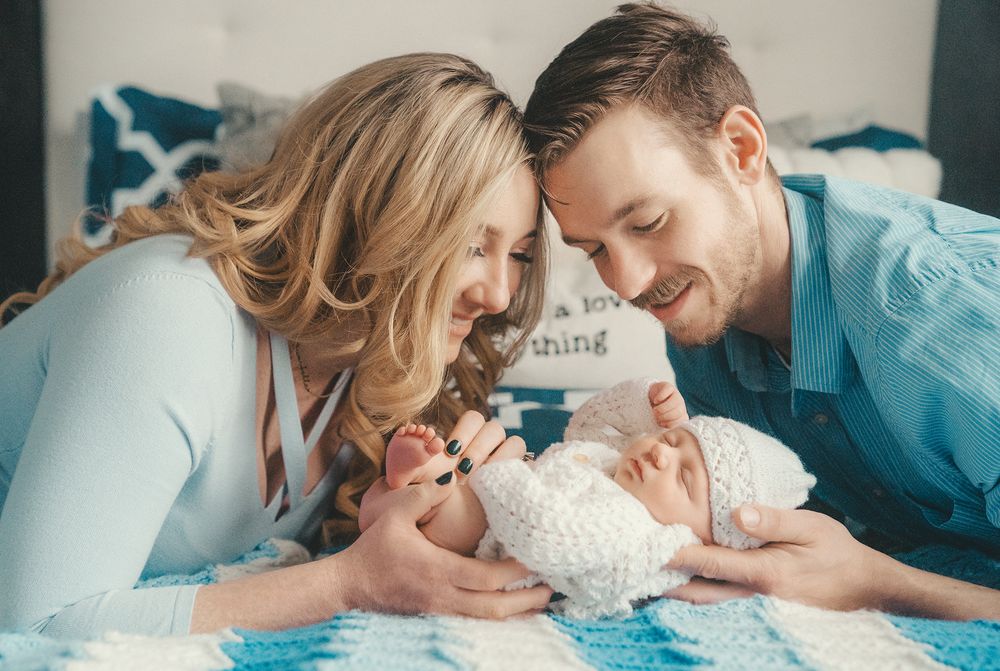 lifestyle newborn photo session in the comfort of a home with the baby girl and the parents in Vaughan, Ontario