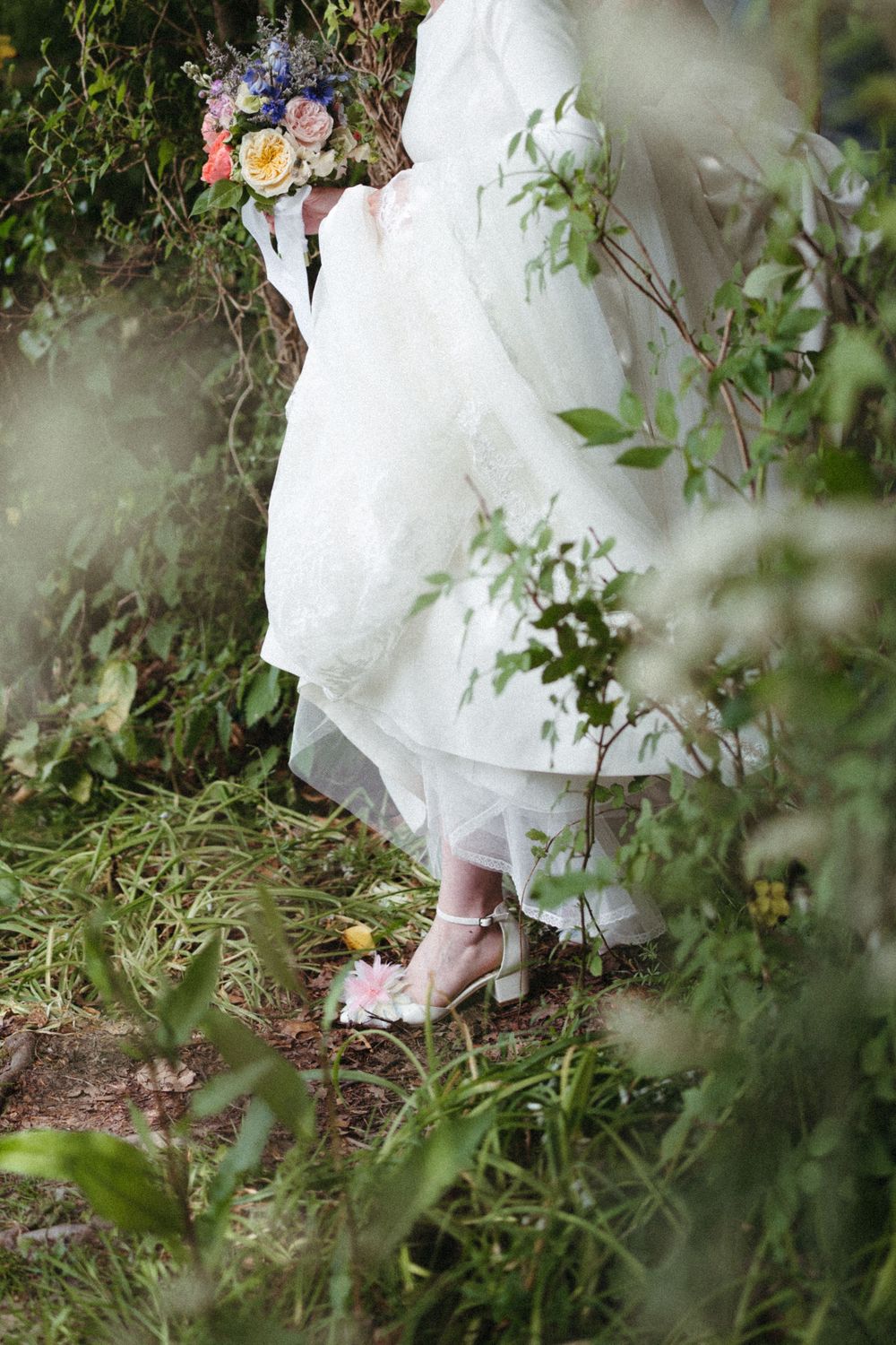 Ethereal close-up shots of a white wedding dress flowing among natural foliage and greenery in a garden setting.