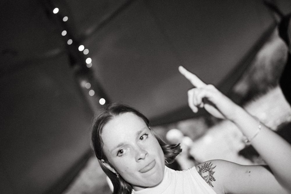 Black and white shots of guests celebrating and dancing at a festive wedding reception.