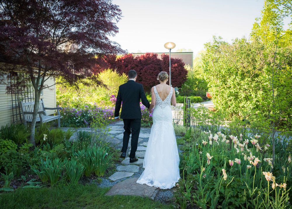 A couple walks through a spring garden path lined with blooming iris flowers.